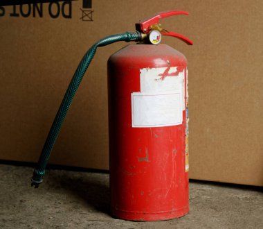 Depodaki eski kırmızı yangın söndürücü. kahverengi kutu arka planı. yakın plan