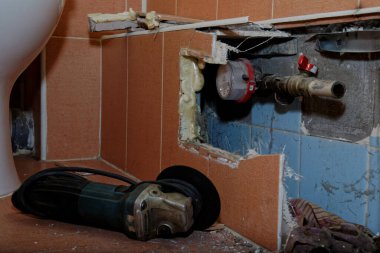 Fayansın altındaki kırık boruyu tamir et. Tuvaletin astarını açmak.