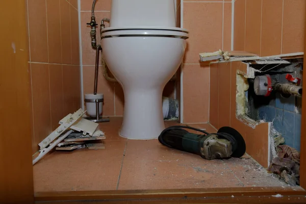 Repareer een gebroken pijp onder de tegel. het openen van de voering van het toilet — Stockfoto