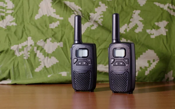 Radio communication device on green khaki background. Handheld walkie talkie for outdoor