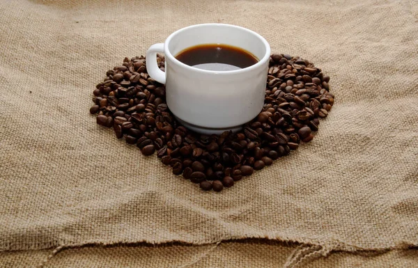 Serce Wykonane Ziaren Kawy Góry Centrum Biały Kubek Kawą Tło — Zdjęcie stockowe
