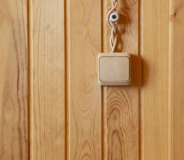 Ahşap bir duvarda çift ahşap elektrik düğmesi. Kablolar dışarı çıkıyor. Köy evi. yakın plan.