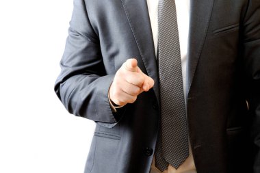 Modern gri takım elbiseli bir adam parmağını ileri uzatıyor. Beyaz arka plan. İş hayatı konsepti. Boşluğu kopyala.
