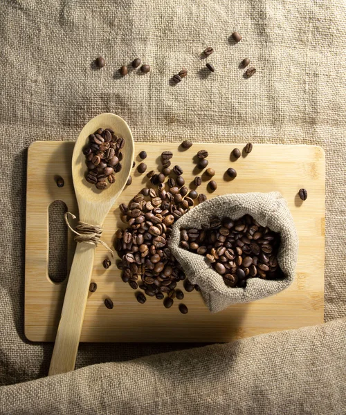 coffee beans in a bag with a wooden spoon.