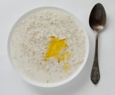 Sabah beyaz bir masada bir dilim tereyağlı yulaf ezmesi. Sağlıklı kahvaltı. düz yat.