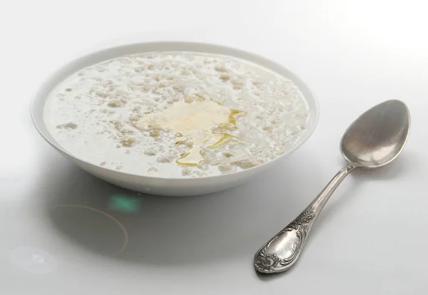 Oatmeal Dengan Sepotong Mentega Atas Meja Putih Pagi Hari Sarapan — Stok Foto