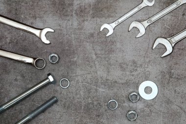 Halka açıcılar ve sıradan ingiliz anahtarı, civata somunu ve gri beton arka planda çamaşır makineleri. Tamir konsepti, araba servisi fotokopi alanı, düz döşeme. Baba günü.