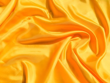 Arkaplanda dalgalar hareket eden parlak sarı ipek. Kopya alanı ile soyut tasarım