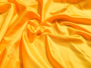 Arkaplanda dalgalar hareket eden parlak sarı ipek. Kopya alanı ile soyut tasarım