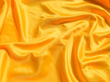 Arkaplanda dalgalar hareket eden parlak sarı ipek. Kopya alanı ile soyut tasarım