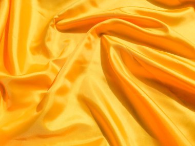 Arkaplanda dalgalar hareket eden parlak sarı ipek. Kopya alanı ile soyut tasarım