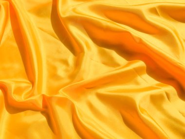 Arkaplanda dalgalar hareket eden parlak sarı ipek. Kopya alanı ile soyut tasarım