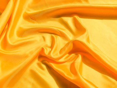 Arkaplanda dalgalar hareket eden parlak sarı ipek. Kopya alanı ile soyut tasarım