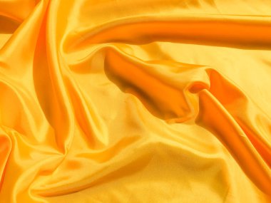 Arkaplanda dalgalar hareket eden parlak sarı ipek. Kopya alanı ile soyut tasarım