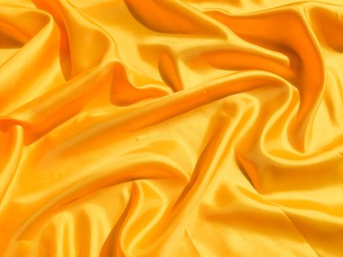 Arkaplanda dalgalar hareket eden parlak sarı ipek. Kopya alanı ile soyut tasarım