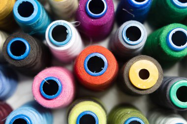 Farklı renklerde ipliklerle dolu bir makara yığını. - Yakın çekim. Üst Manzara. Arkaplan