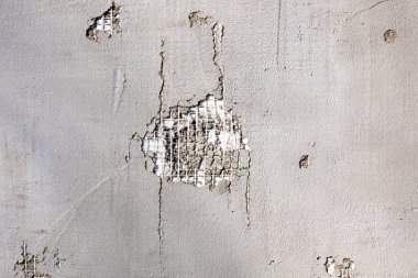Soyulmuş bir duvar görüntüsü. Duvarın bir kısmı hasar görmüş. Hasarlı alçı yüzeyi. Kırık alçılı duvar