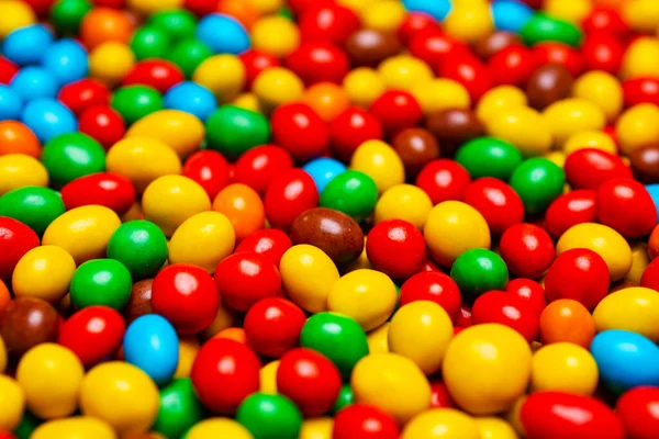 Image of colored round sweets. Background of small multicolored dragees. Closeup. Side vew.