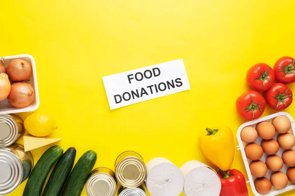 Food donations on yellow background. Food help . Top view with copy space