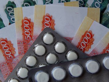 Altın arka plan haplarla parayla. Tıbbi trea maliyetini kavramı