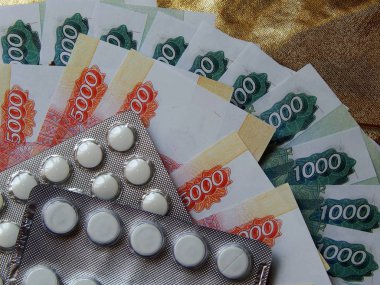 Altın arka plan haplarla parayla. Tıbbi trea maliyetini kavramı