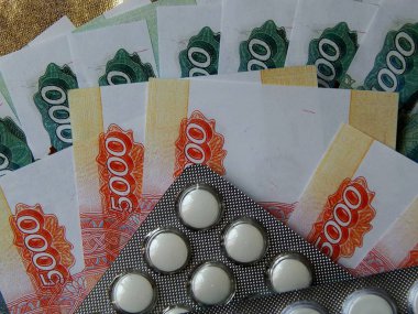 Altın arka plan haplarla parayla. Tıbbi trea maliyetini kavramı