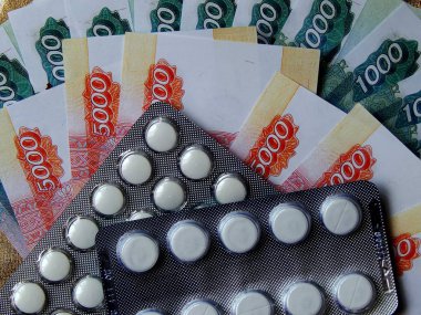 Altın arka plan haplarla parayla. Tıbbi trea maliyetini kavramı