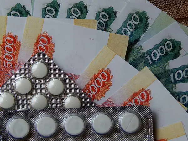 Altın arka plan haplarla parayla. Tıbbi trea maliyetini kavramı