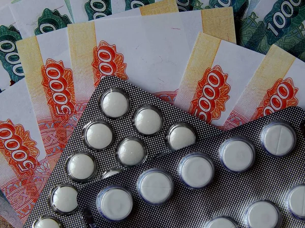 Altın arka plan haplarla parayla. Tıbbi trea maliyetini kavramı