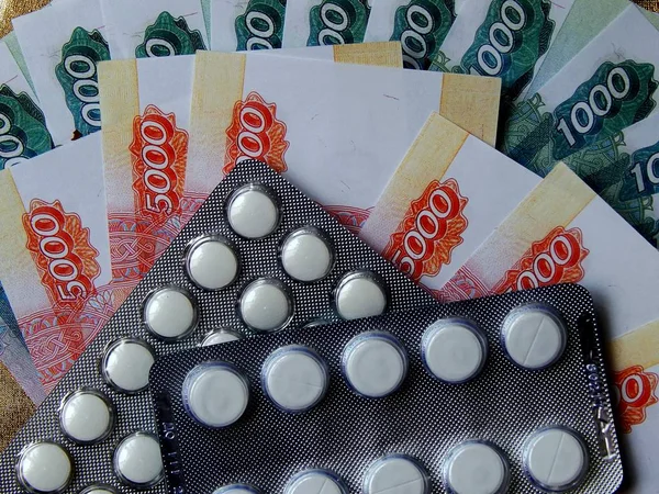 Altın arka plan haplarla parayla. Tıbbi trea maliyetini kavramı