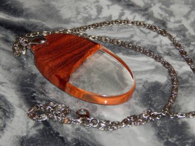 Tahtadan yapılmış, epoksi reçineli bir kolyenin yakın çekimi.