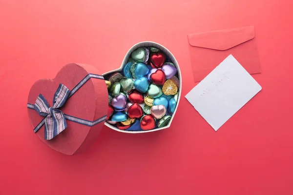 Heart shape candy in a box on red background — Stock Photo, Image