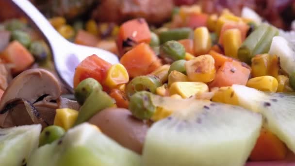 Gros plan de la cuillère et des légumes frais sur l'assiette — Video