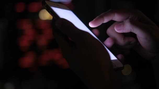 女性の閉鎖手は夜にスマートフォンを使用します — ストック動画