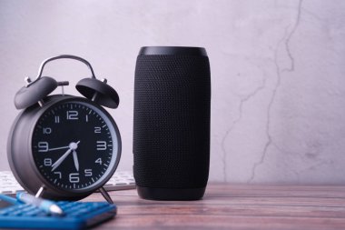 smart speaker with clock on table against a wall 