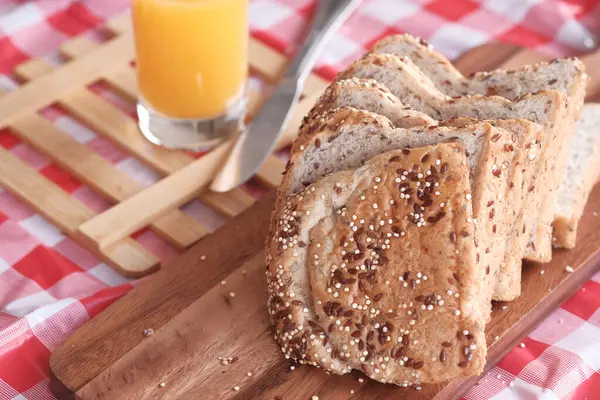Detailní záběr hnědého chleba a pomerančové šťávy na stole — Stock fotografie