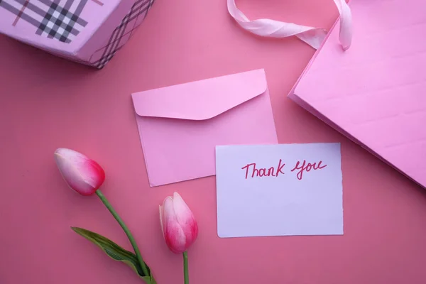 thank you note message and gift box on color background