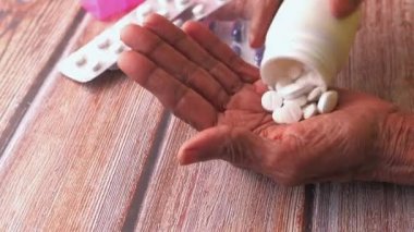 Yaşlı kadınların eline hap dökülmesi yakın plan. 