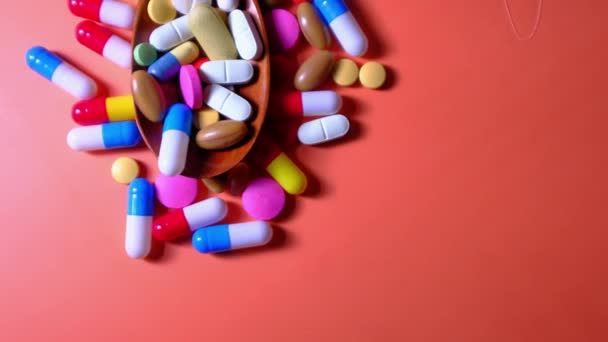 Разноцветные таблетки и капсула на ложке, вид сверху — стоковое видео
