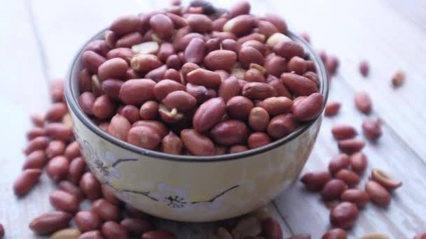 Closeup of peanut in a bowl on wooden table — Stock Video