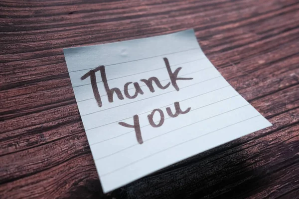 Ręcznie napisane podziękowania wiadomość na papierze na stole — Zdjęcie stockowe