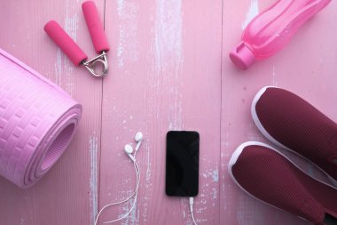 Ayakkabılı, dambılı ve akıllı telefonlu spor aletleri. 