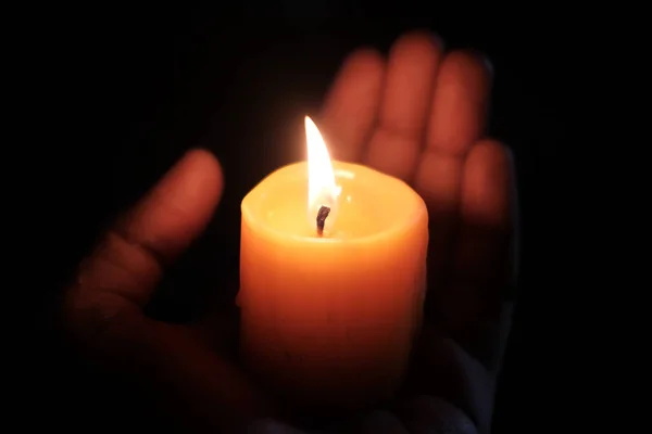 Brännande ljus på kvinnor hand på natten, närbild — Stockfoto