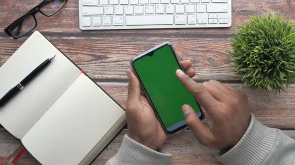 Vista superior del hombre uso de la mano teléfono inteligente en el escritorio de la oficina — Vídeos de Stock