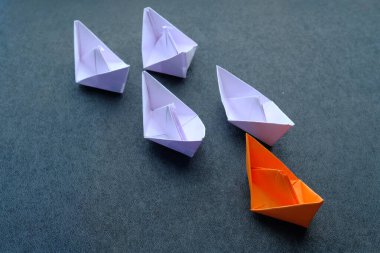 Leadership concept with paper boat on table 