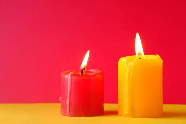 Two Burning candle on color background, close up — Stockfoto