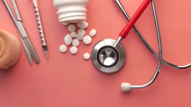 Top view of pills, contianer and stethoscope on color background — 图库视频影像