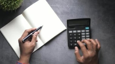 top view of man hand use calculator on table 