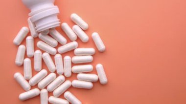 Konteynırdan dökülen beyaz kapsülün üst görünümü 