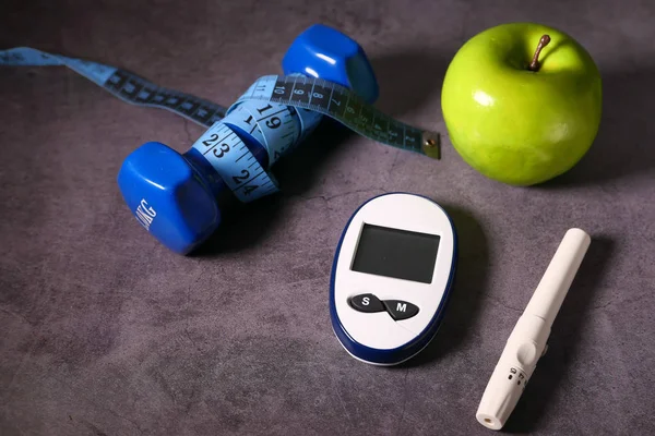 Närbild av diabetiska mätverktyg och äpple på bordet — Stockfoto